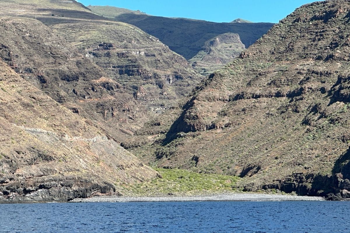 Blue Sea And A Rocky Beach Known As Playa De La Negra La Gomera Canary Islands Spain With Steep Mountains In Background