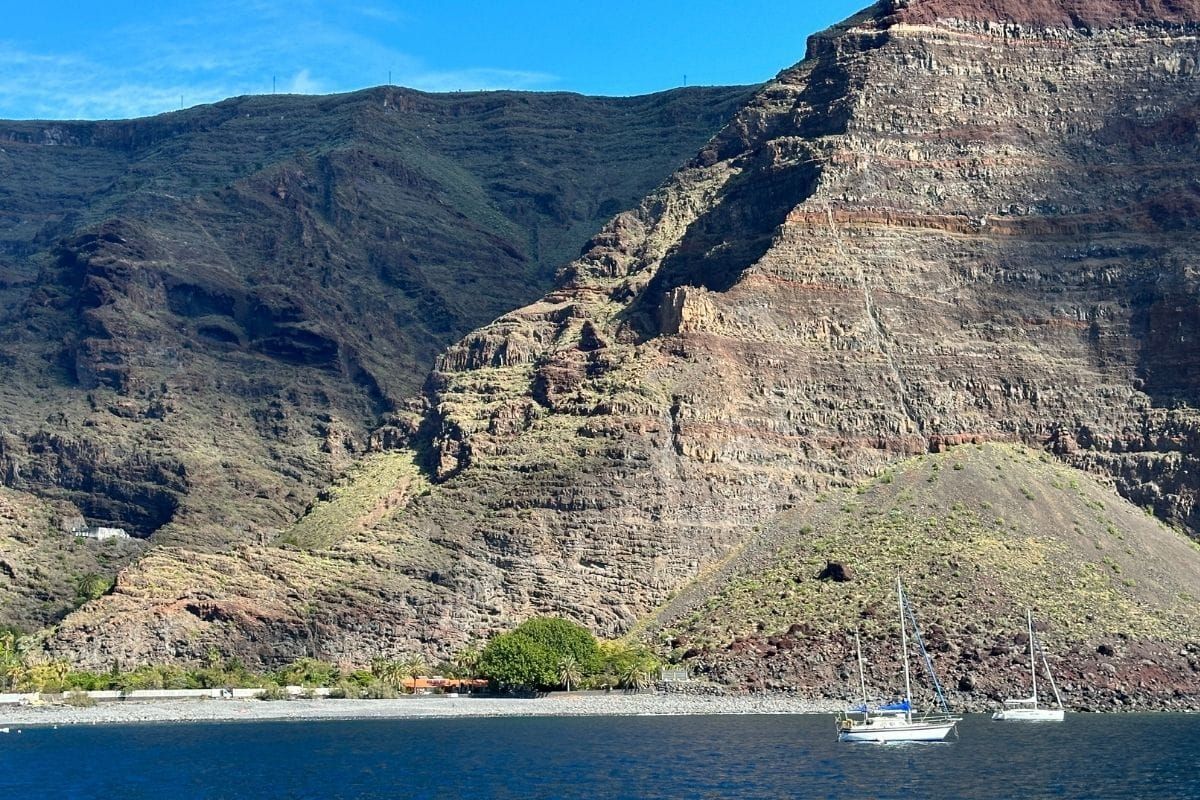 Blue Sea And A Sandy Beach Known As Playa De Las Arenas La Gomera Canary Islands Spain With Mountains In The Background