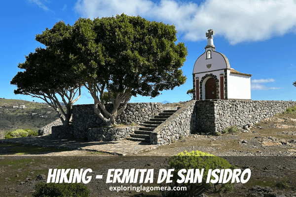 Beautiful Ermita De San Isidro La Gomera Canary Islands Spain Sits Above Stone Wall With Tree In Foreground And Blue Sky And