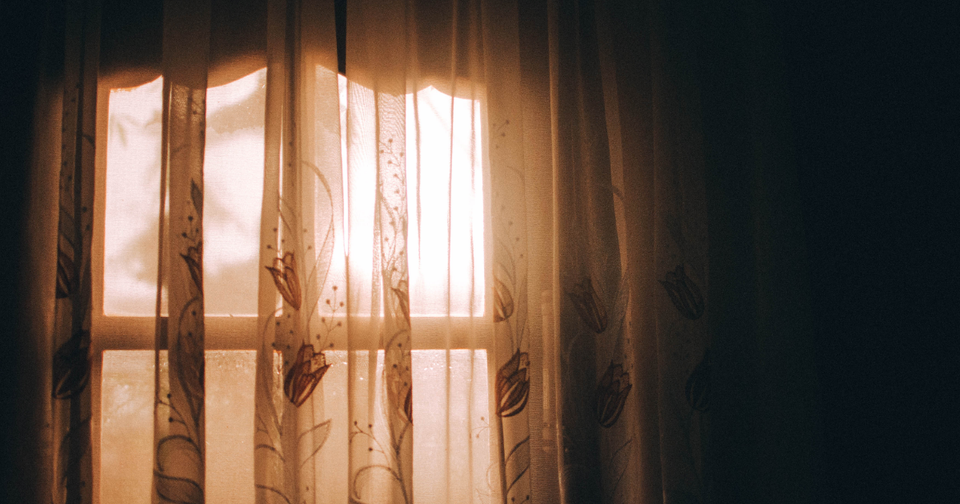 Sunlight coming through a window with sheer curtains