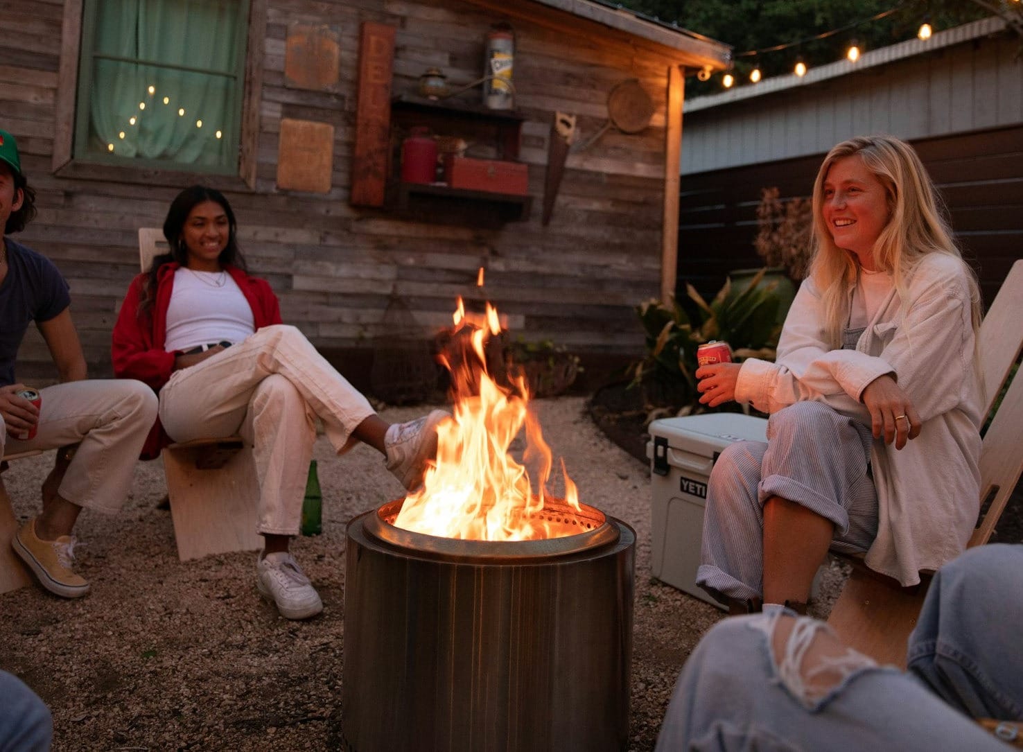 a group of people sitting around a fire pit