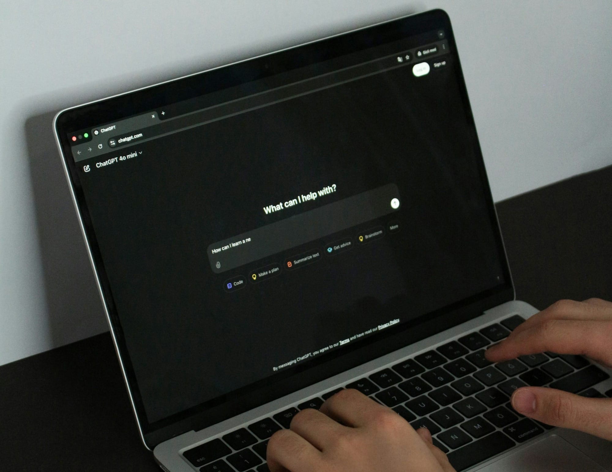A person typing on a laptop on a table