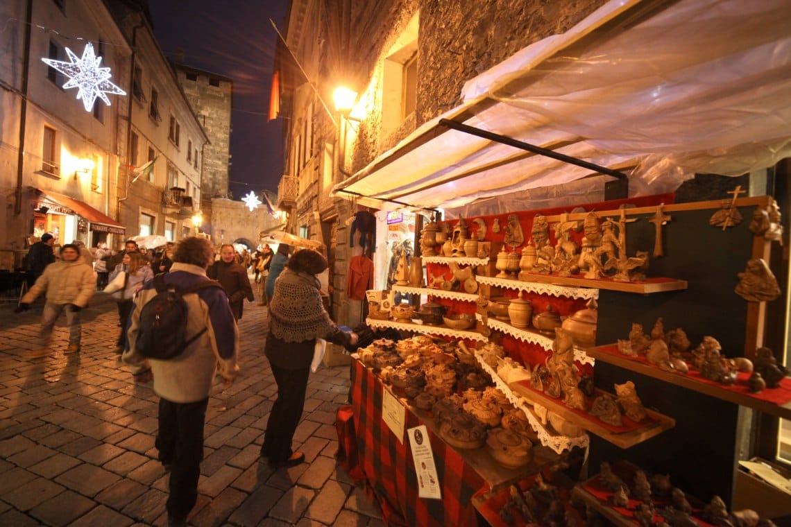 Aosta bustling street with market and people walking along