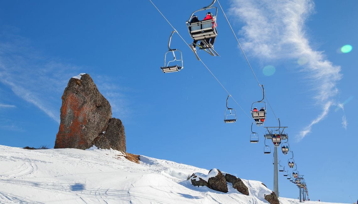 Rocky outcrop in Arabba with chairlift passing by and blue skies