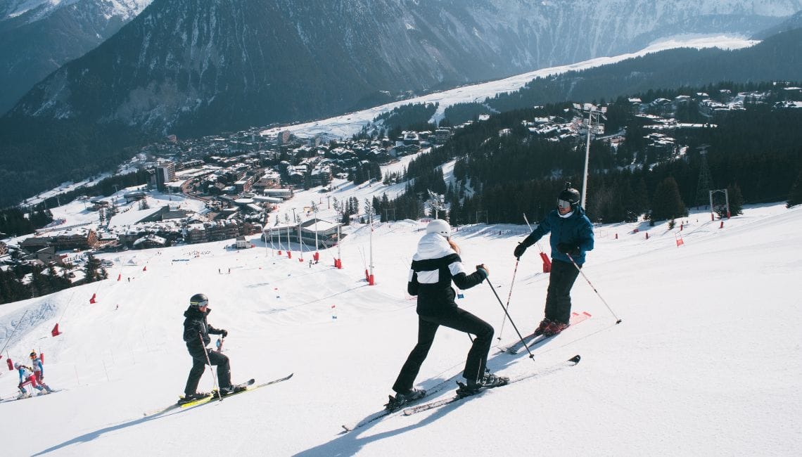 View of people on a slope which goes down into one of Courchevel's villages