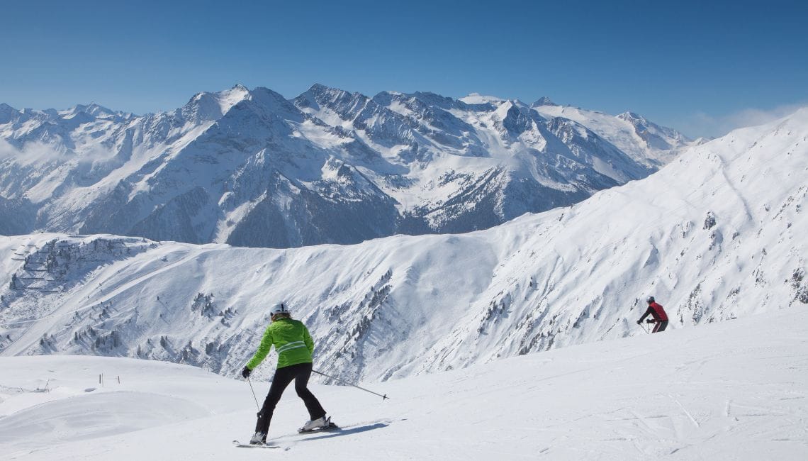 Beginner skier doing a snow plough on wide, gentle slope