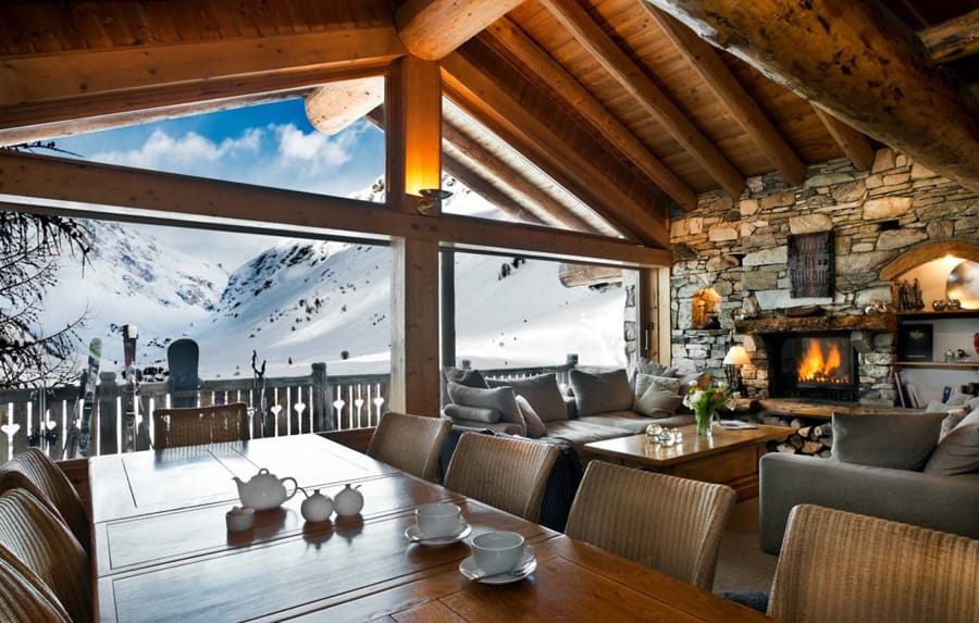 Inside of luxury chalet in Val d'Isere with table, sofas and fireplace