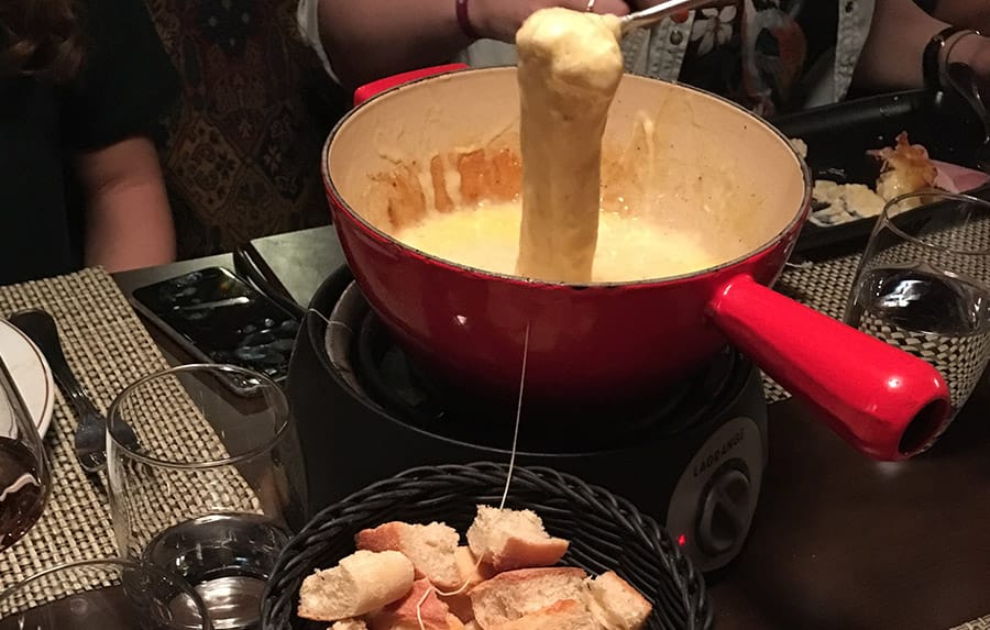 Pan of fondue cheese with bread