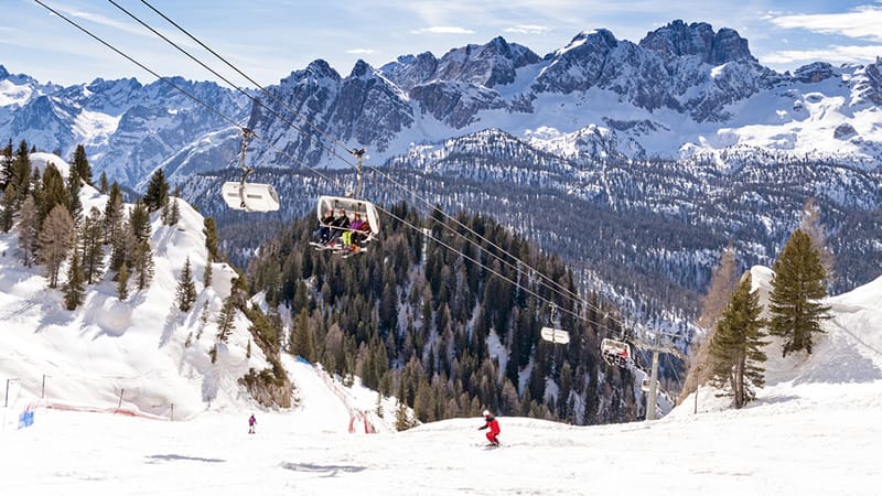 Tree skiing in Sella Ronda with blue skies and chairlift
