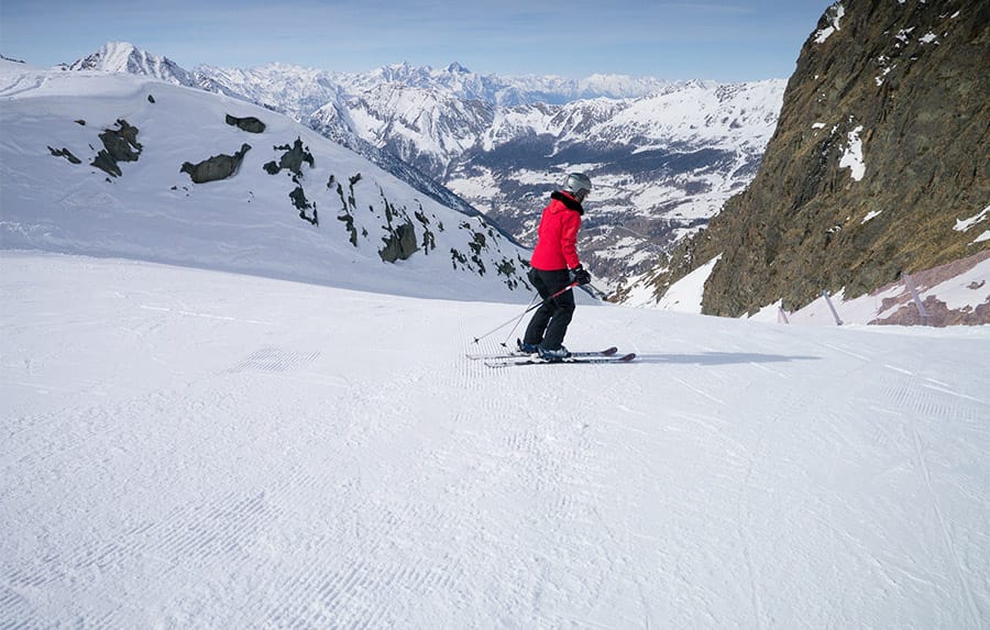 Person skiing down red run in Champoluc with beautiful scenery ahead