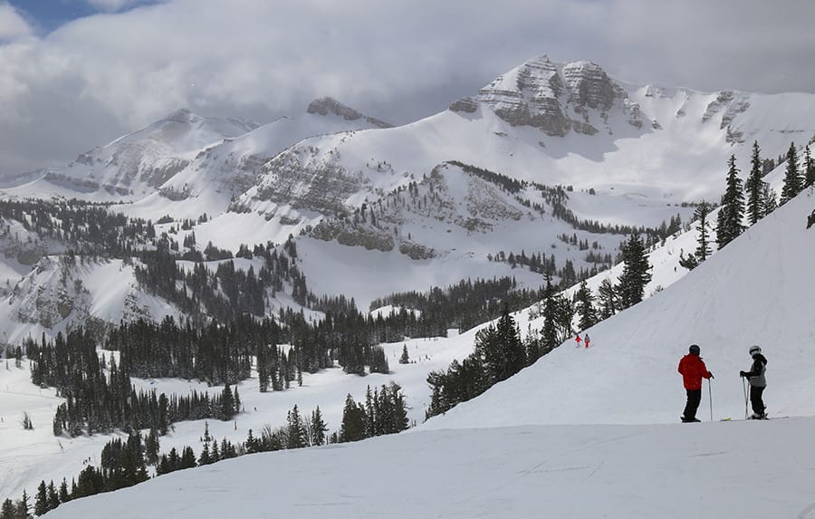 Skiers pause and chat on run in Jackson Hole with spectacular backdrop
