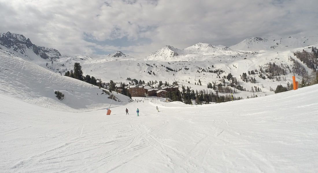 Skiers going down wide open slope