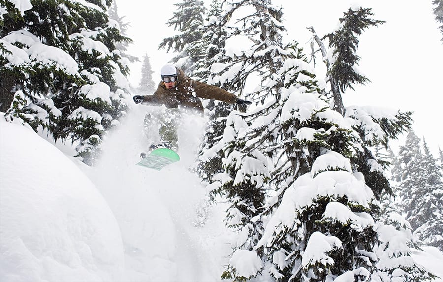 Snowboarder emerging from trees in Avoriaz