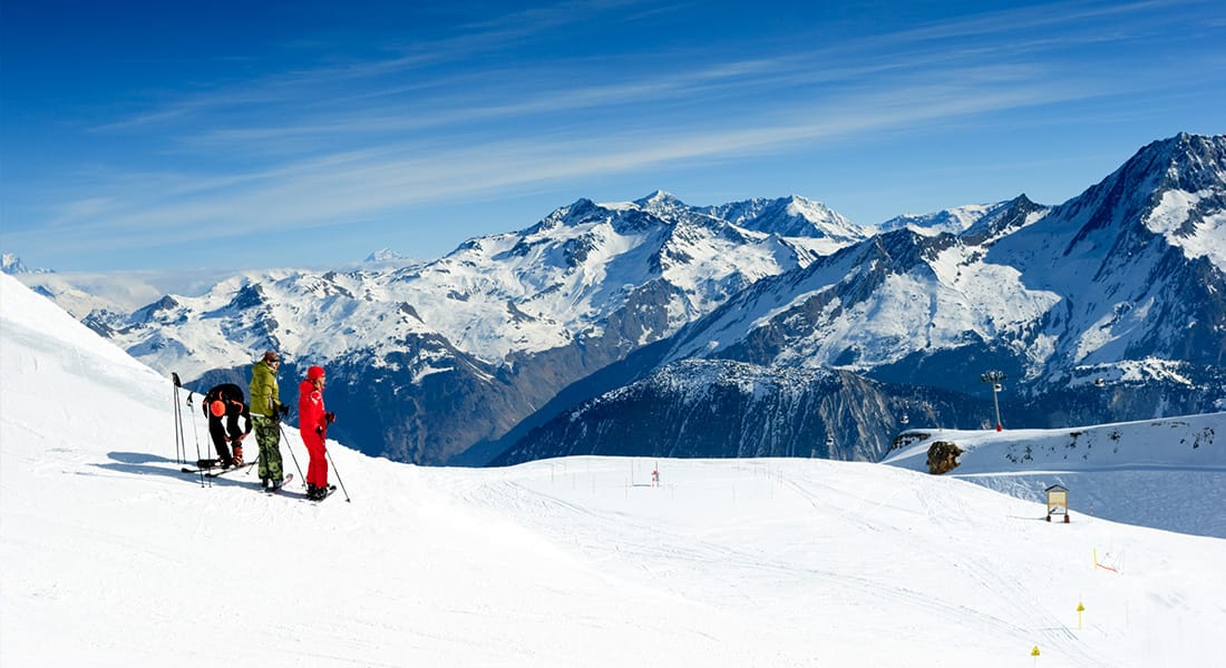 3 skiers look down a slope in Meribel