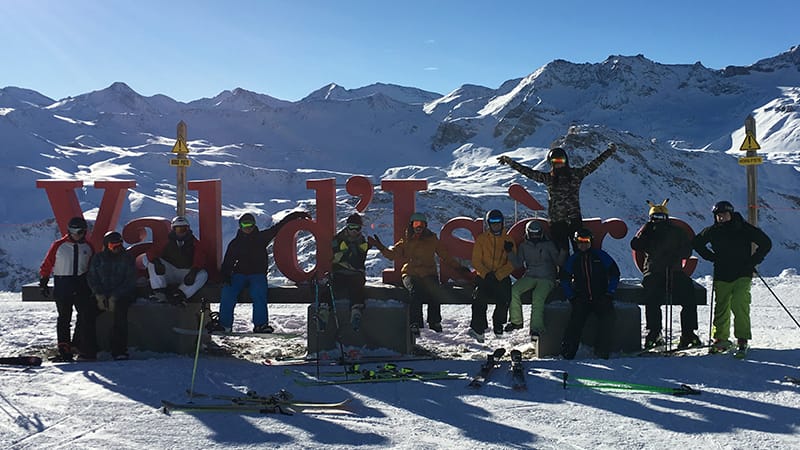 Iglu Ski team standing at the Val d'Isere sign with mountain backdrop