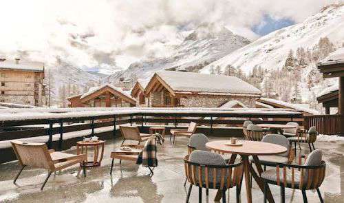 Balcony of Club Med Val d'Isere with comfortable chairs and tables and beautiful mountain view