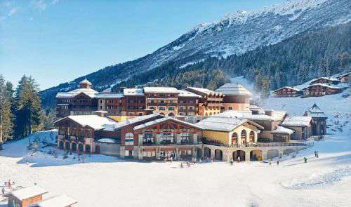 Aerial shot of Club Med Valmorel with mountain landscape and blue skies