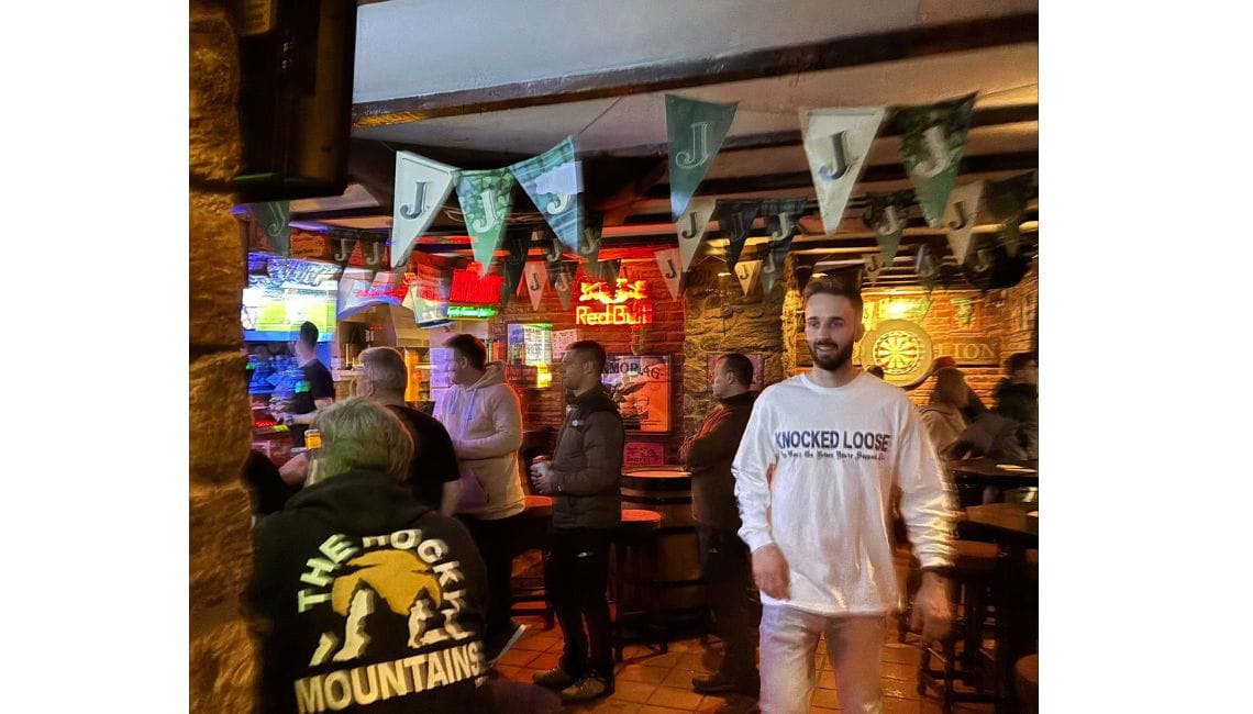 Inside of Red Lion pub with people queuing at bar and tables and chairs
