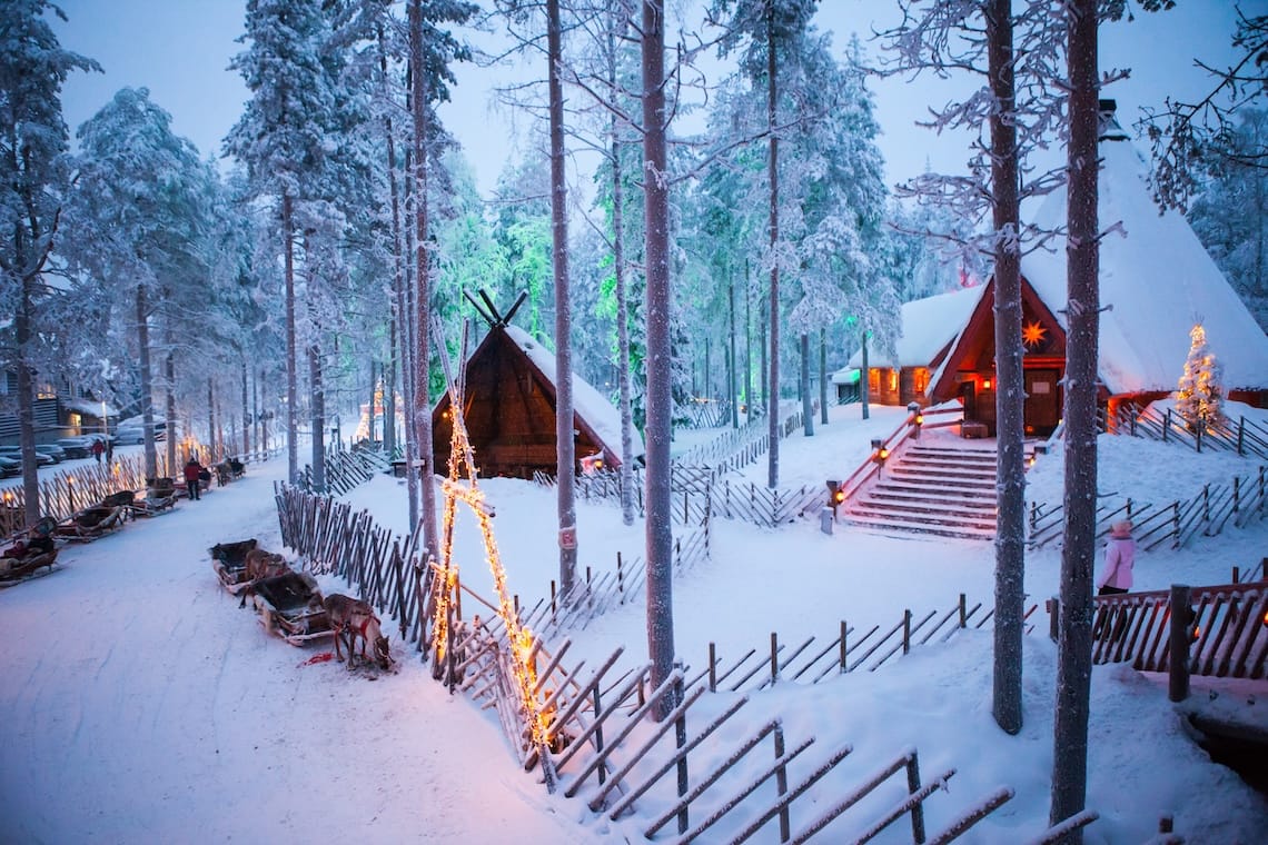 Decorated wooden huts in the snow-covered forest of Lapland's Santa Claus Village