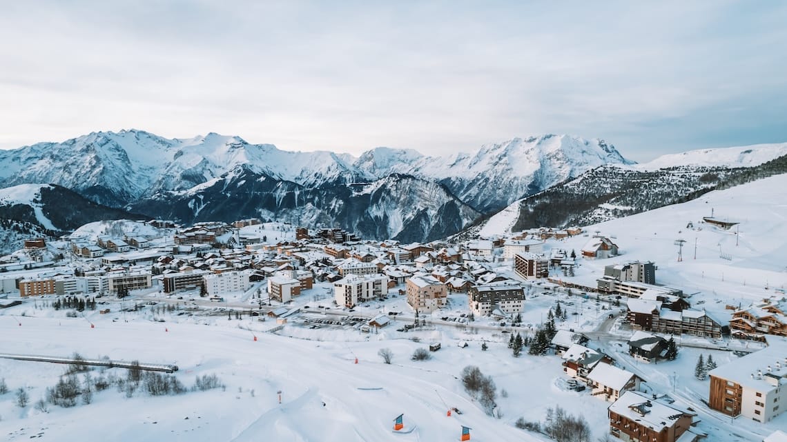 Aerial view of Alpe d’Huez in winter with mountain backdrop