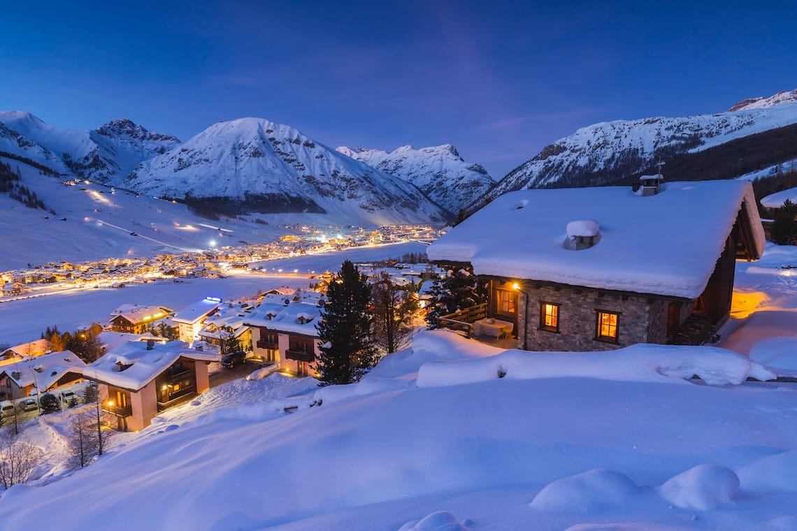 A glowing hut overlooking Livigno ski resort at night