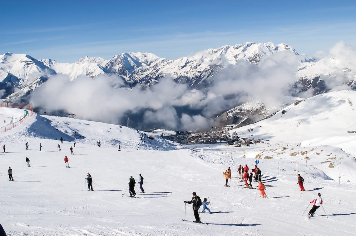 Skiers on sunny pistes above Alpe d'Huez