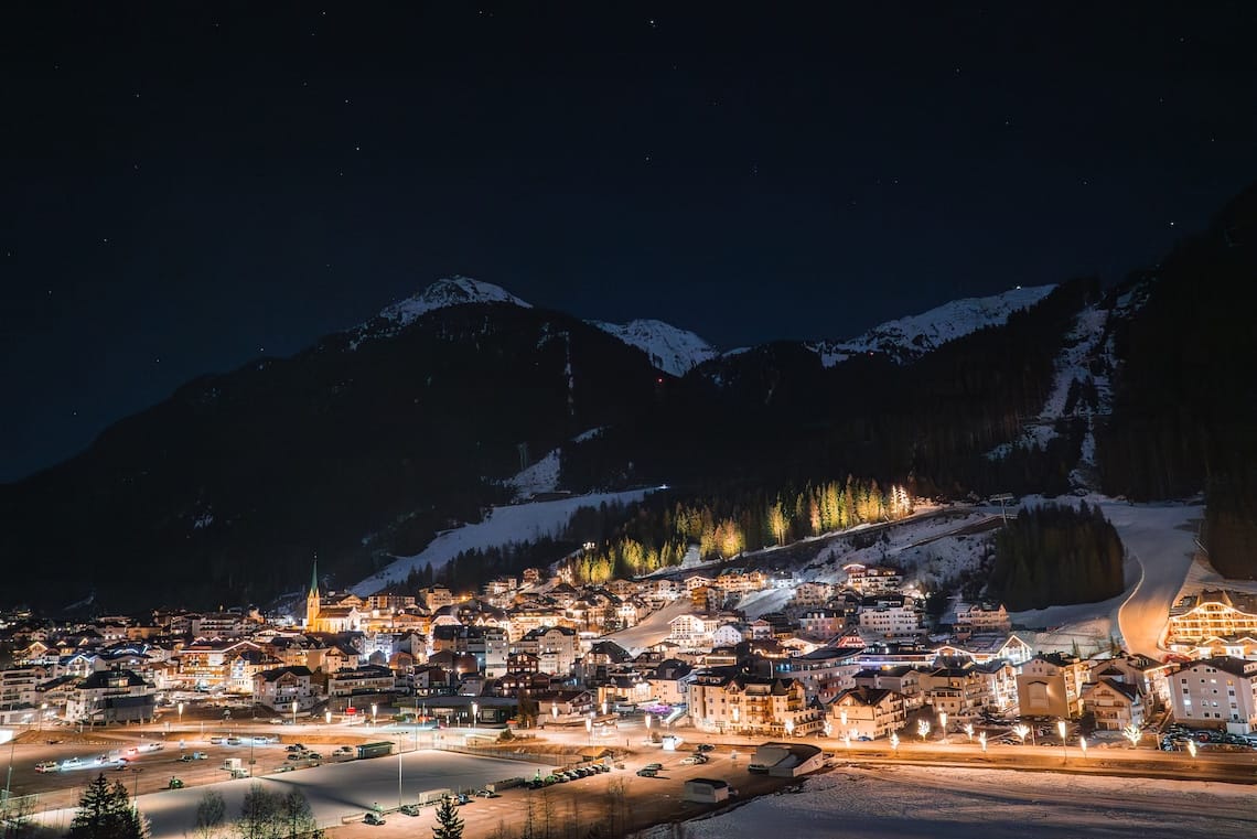 Lit up Ischgl at night, surrounded by snow covered mountains