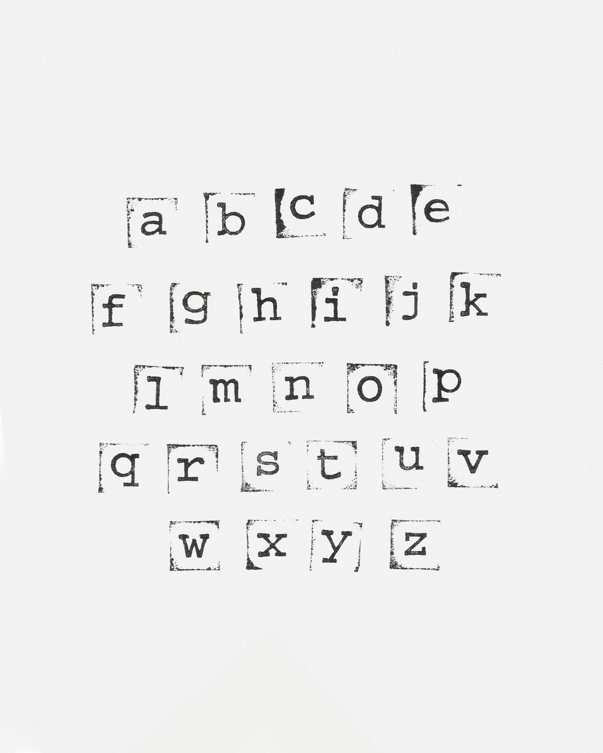 Black and white minimalist photograph of lowercase letters from a to z stamped in individual typewriter-style squares on a plain background.