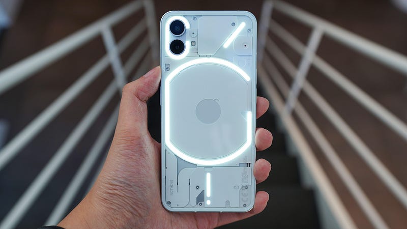 Image of someone holding the Nothing Phone 1. Image from — https://www.gsmarena.com/oneplus_8t-pictures-10420.php