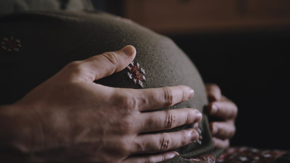 pregnant woman running hand over belly