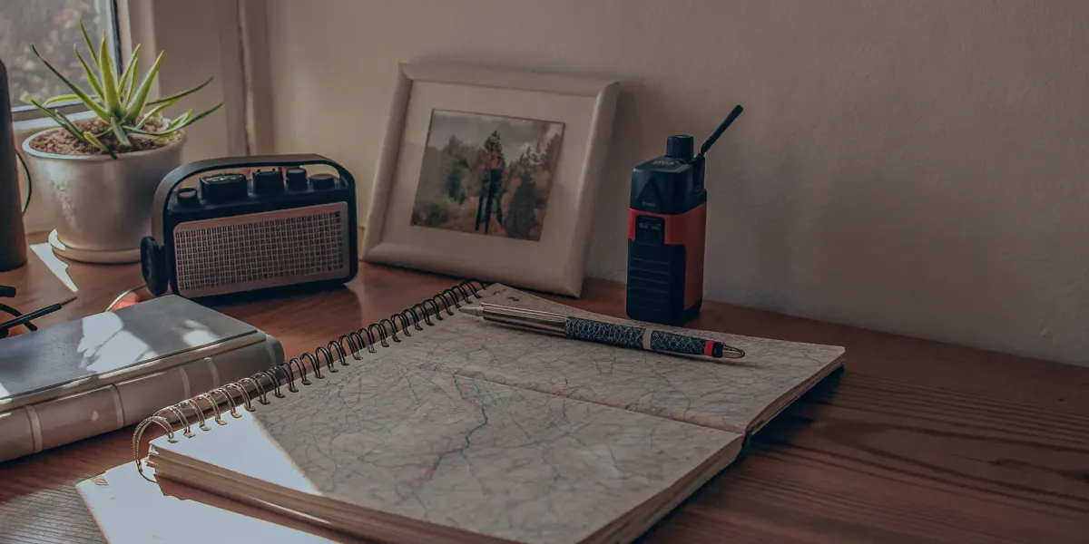 A family's wildfire emergency communication plan laid out on a desk with a map and two-way radio.