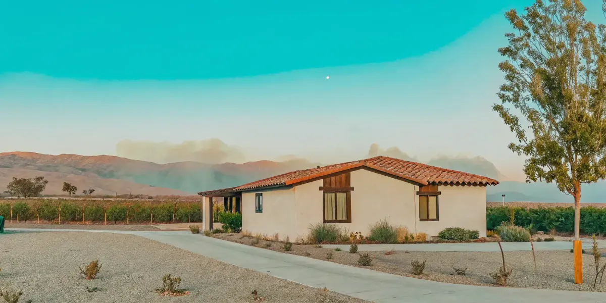 Zone 0 landscaping with gravel and fire-resistant plants creating a defensible space around a home.