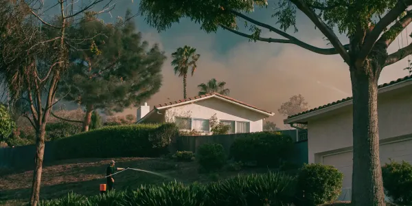 Top 10 wildfire prevention measures: Homeowner watering defensible space.