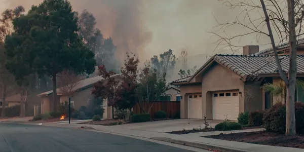 A home's vulnerability to wildfire shown by nearby smoke, a risk managed by an assessment tool.