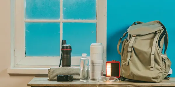 A wildfire emergency supply kit packed in a go-bag with water, a flashlight, and safety goggles.