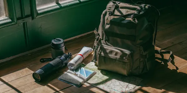 Family go bag packed with emergency essentials like a flashlight, water bottle, and map.