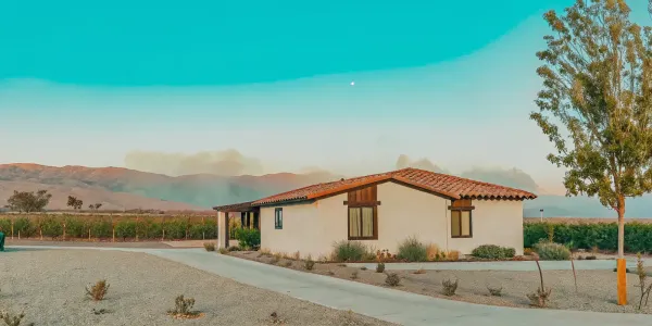 Zone 0 landscaping with gravel and fire-resistant plants creating a defensible space around a home.