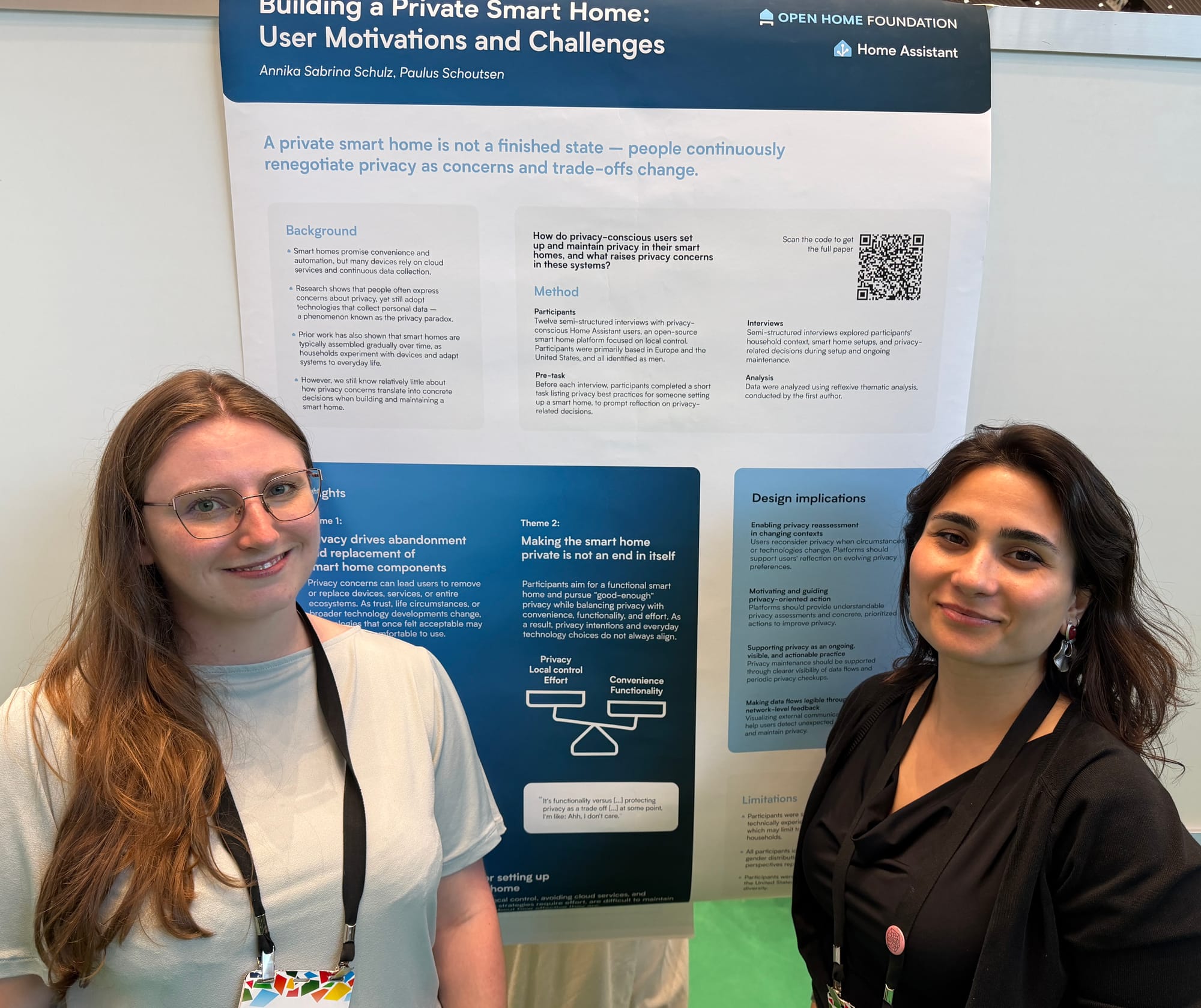 Two woman standing in front of a research poster.