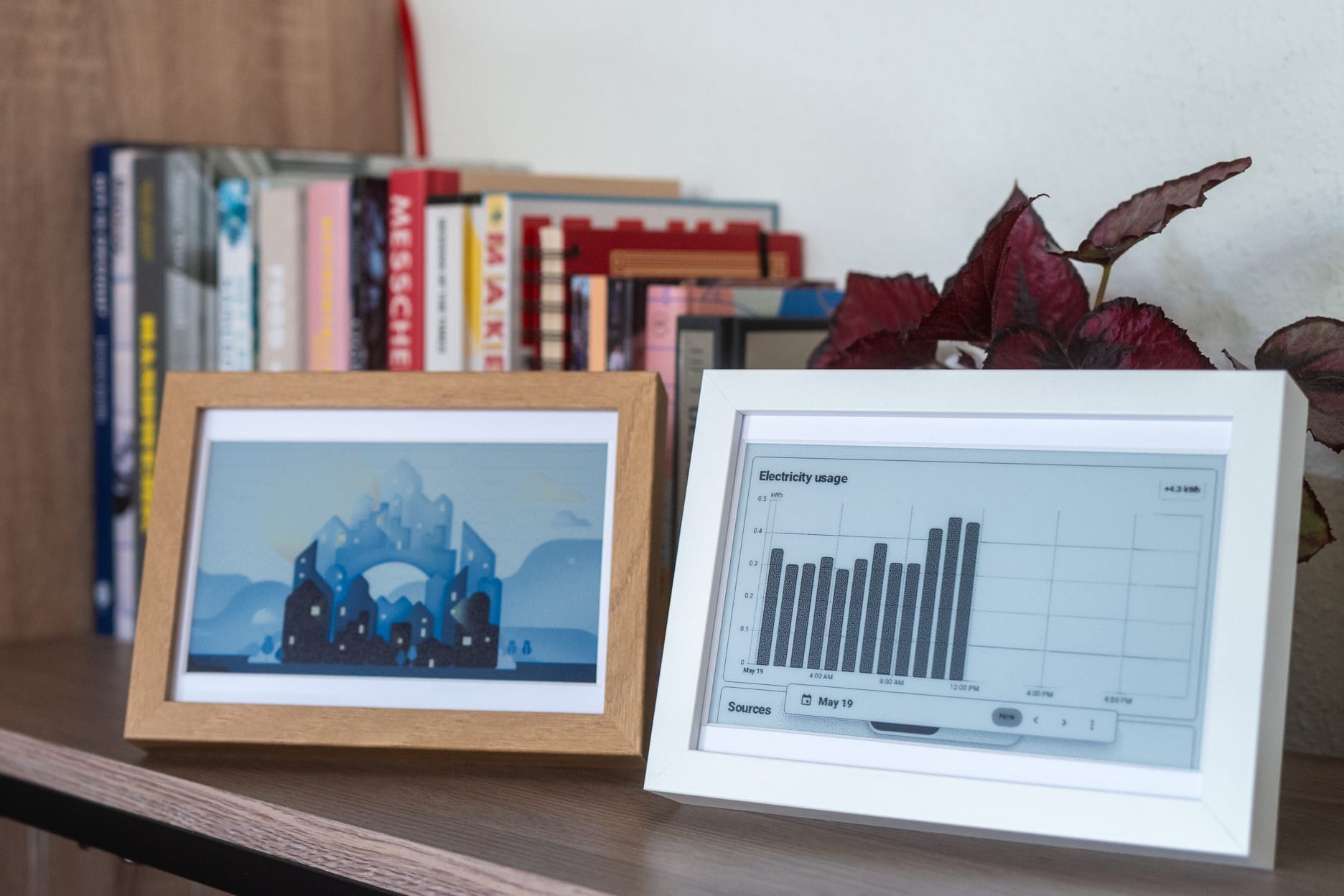 Two e-paper frames on a shelf: one showing art, one showing a home automation dashboard.