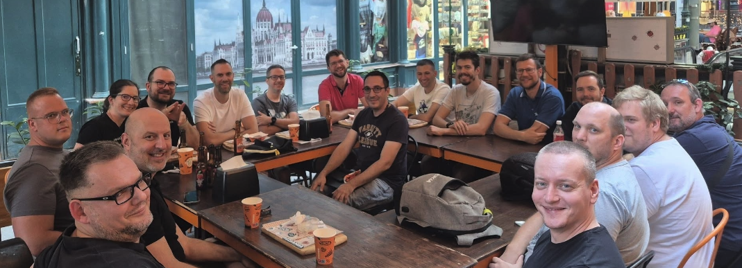 A group of Home Assistant enthusiasts sitting in a square of tables on a bar terrace with one person sat in the middle.
