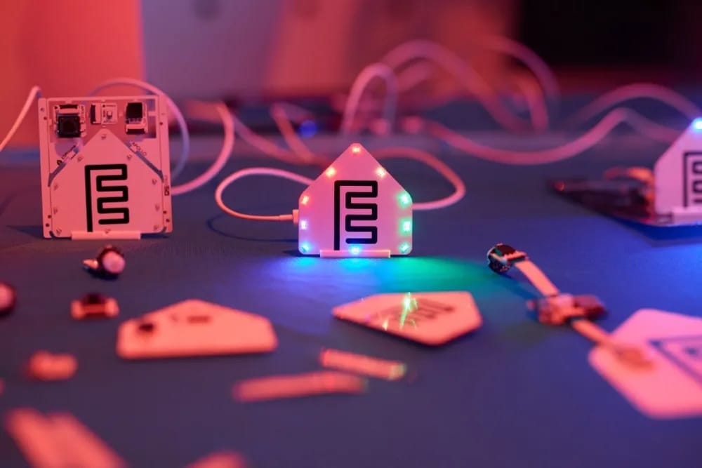 Components of the ESPHome Starter Kit laid out on a table with shining lights