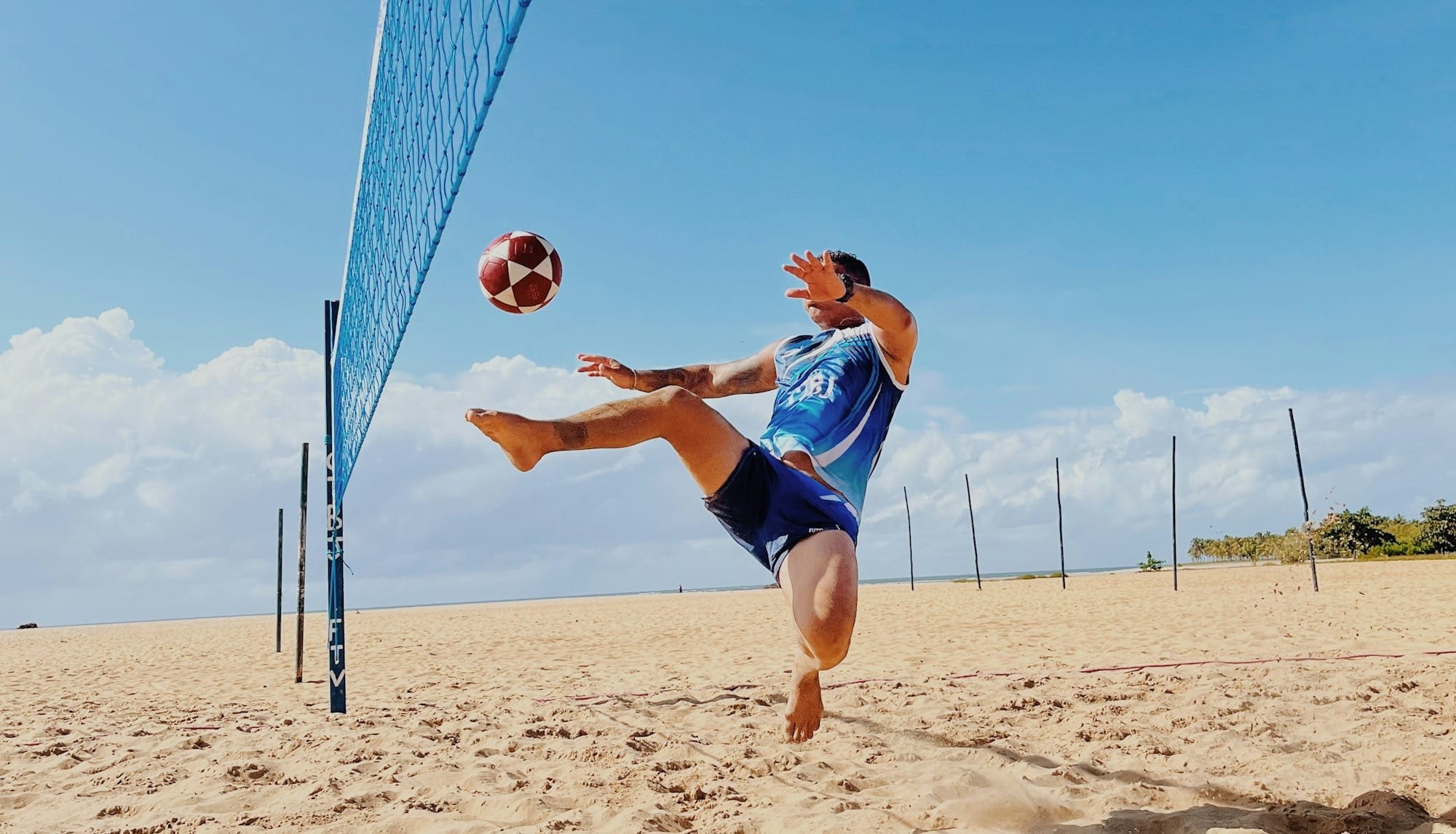 a man is playing volleyball on the beach