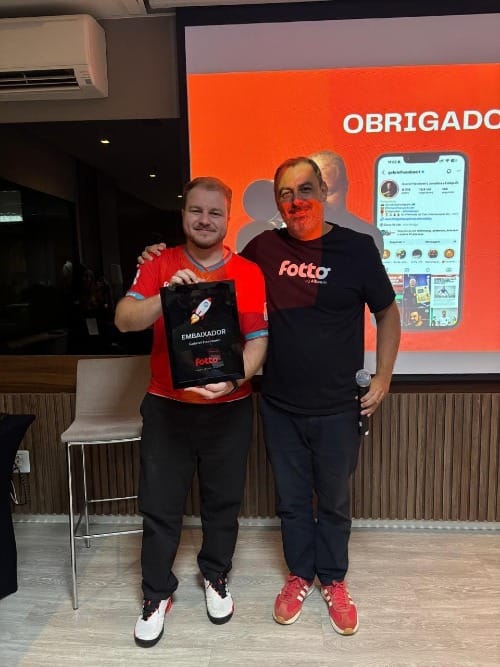 Gabriel Haesbaert recebe uma placa de homenagem como embaixador da Fotto, ao lado do CEO da Fotto, Marcelo Moscato, no workshop Fotto de fotografia esportiva em Brasília.