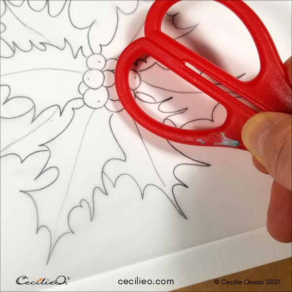 Transferring the outline by pressing down the graphite with a scissor handle.