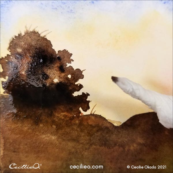 Using a tissue paper rolled into a tip to soak pigments for leafy holes.