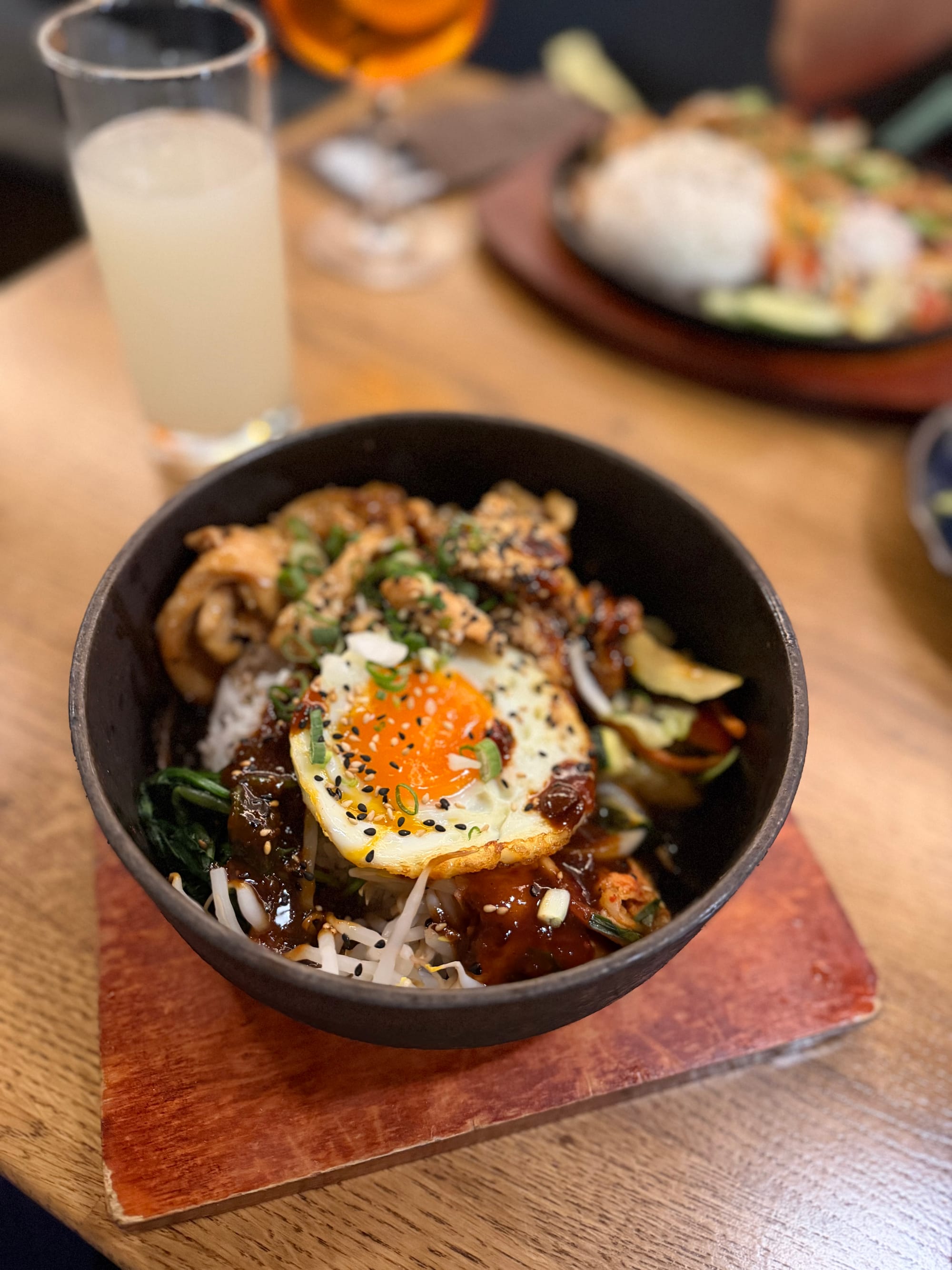 Bibimbap in einem heißen Steinnapf mit Spiegelei, Gemüse, Fleisch und schwarzem Sesam im Seoul Garten Magdeburg © Roman Jasiek