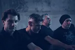 Pressefoto der Band diorama: vier Bandmitglieder in düsterem Blaulicht, nachdenkliche Stimmung, Nahaufnahme der Gesichter (© Thomas Wuhrer)