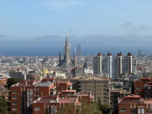 Skyline von Barcelona vom Park Güell aus: Häusermeer mit der Sagrada Família im Zentrum und Baukran, Mittelmeer im Hintergrund (© Nicole Isensee)