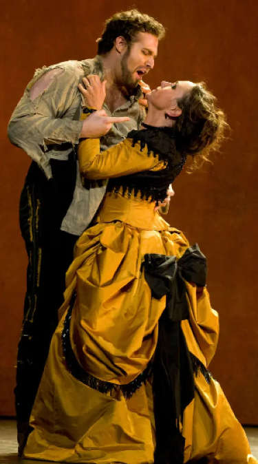 In a scene from the third act of Carmen, a ragged and raging Don José violently grabs and threatens Carmen.