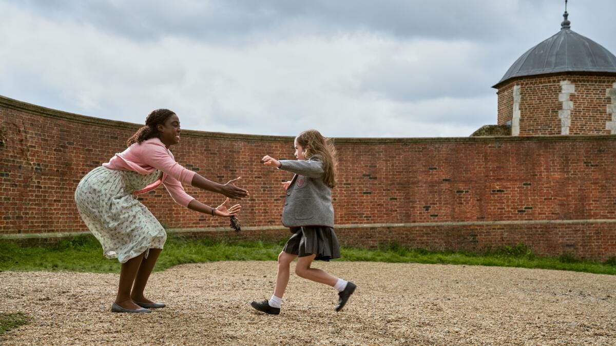 An adorable little girl rushes to the arms of a kind woman.